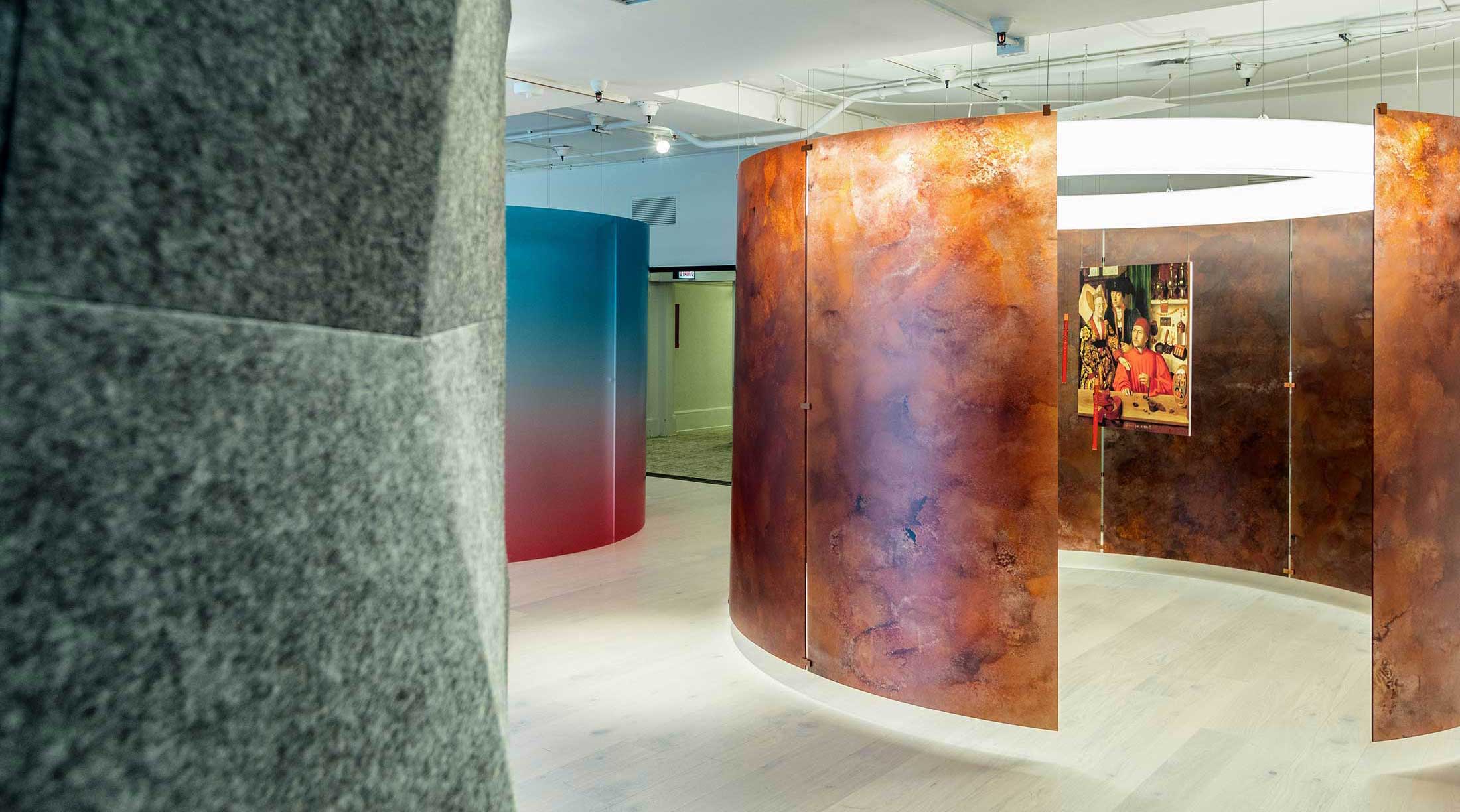 A room with several different colored walls and a large curved glass wall.