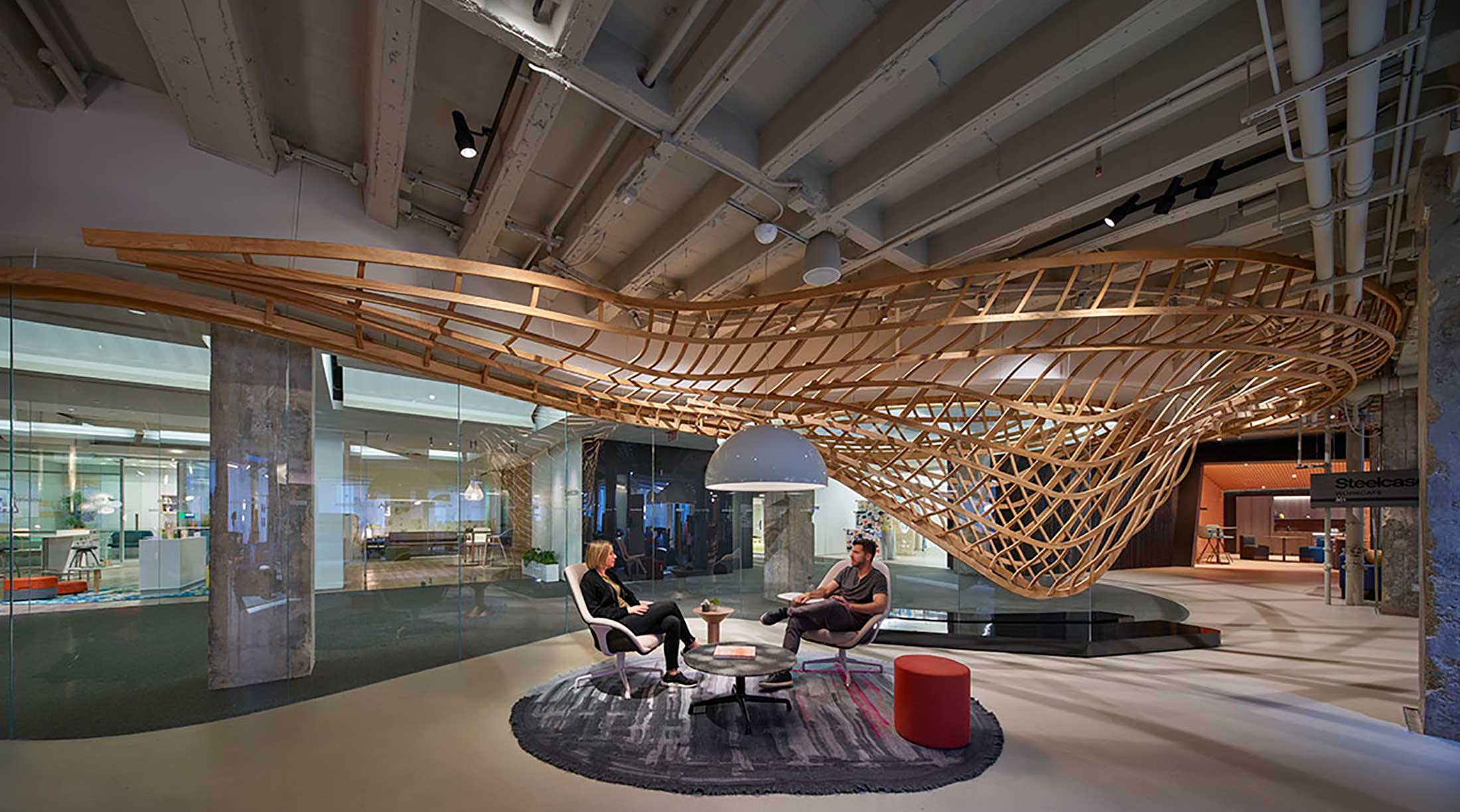 Two people sitting in a room with some chairs