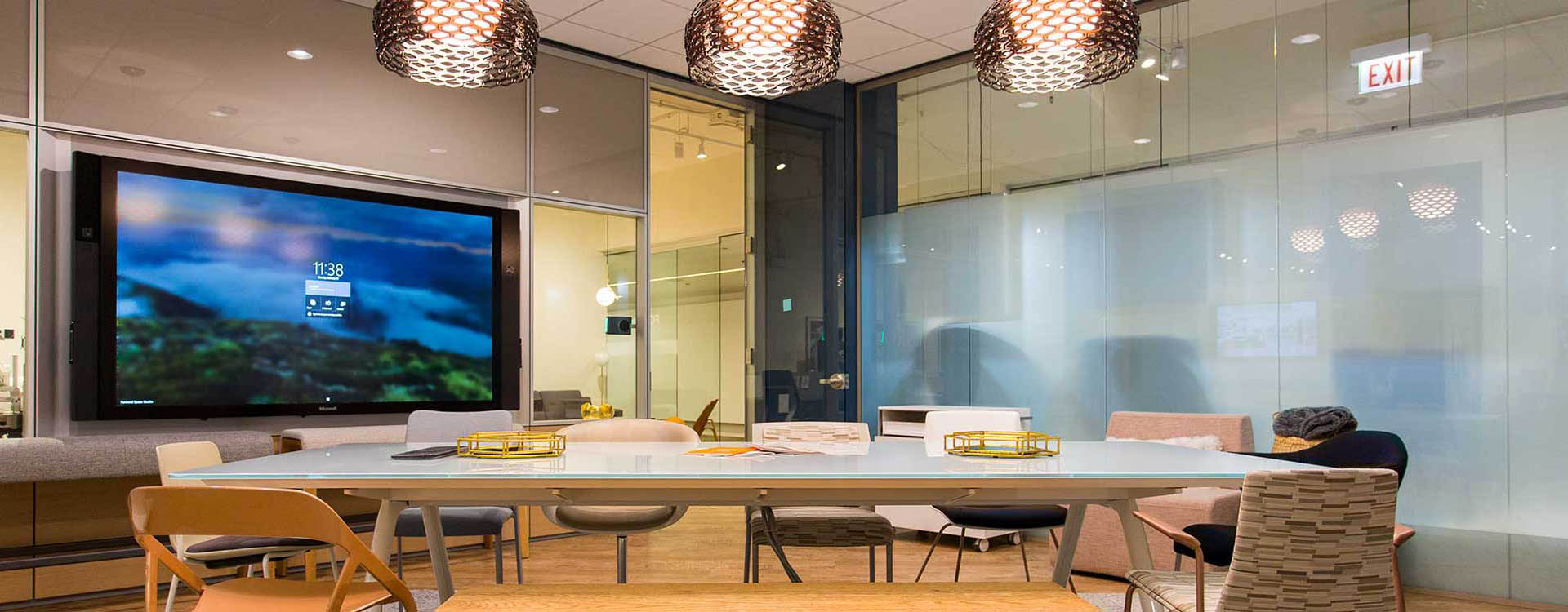 A large table with chairs in front of a wall.