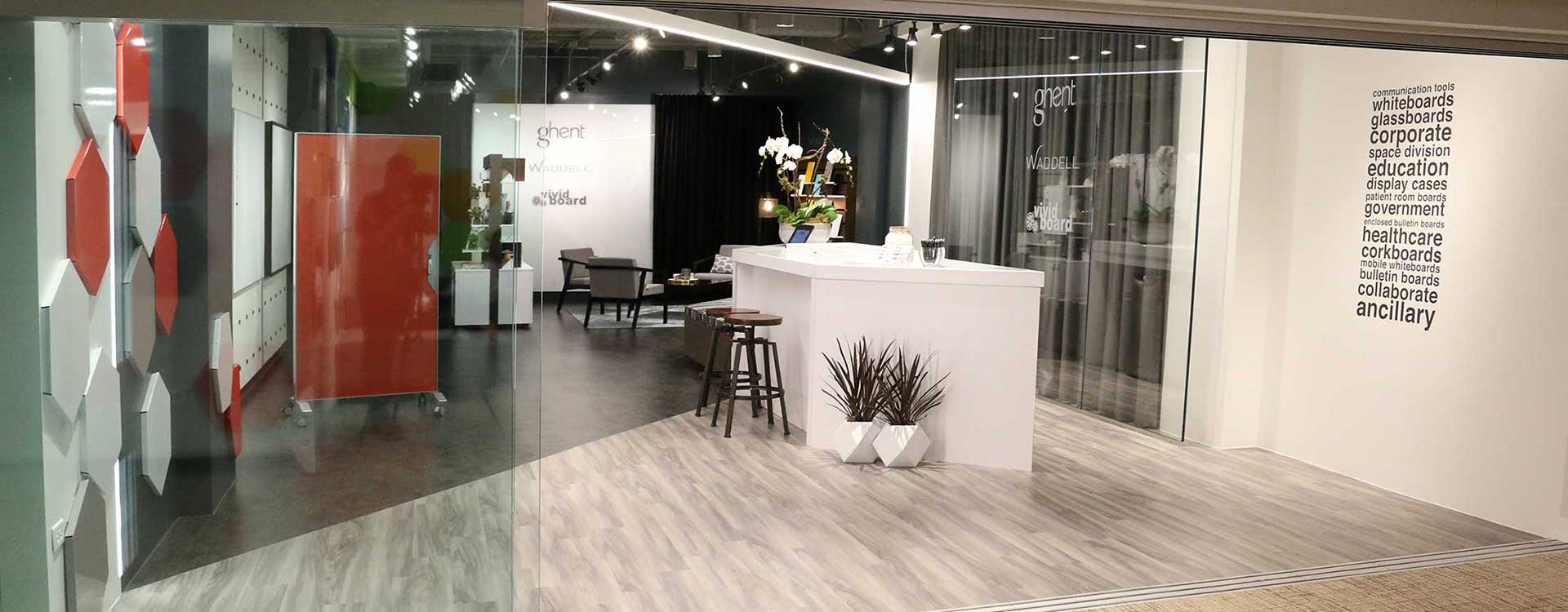 A white counter in an office setting with glass walls.