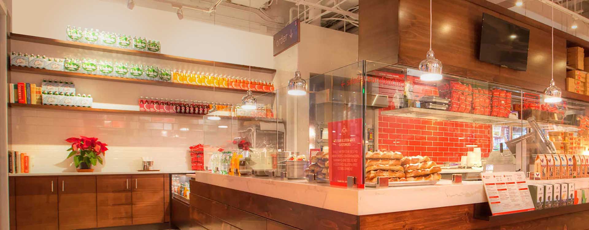A restaurant with many sandwiches on the counter.