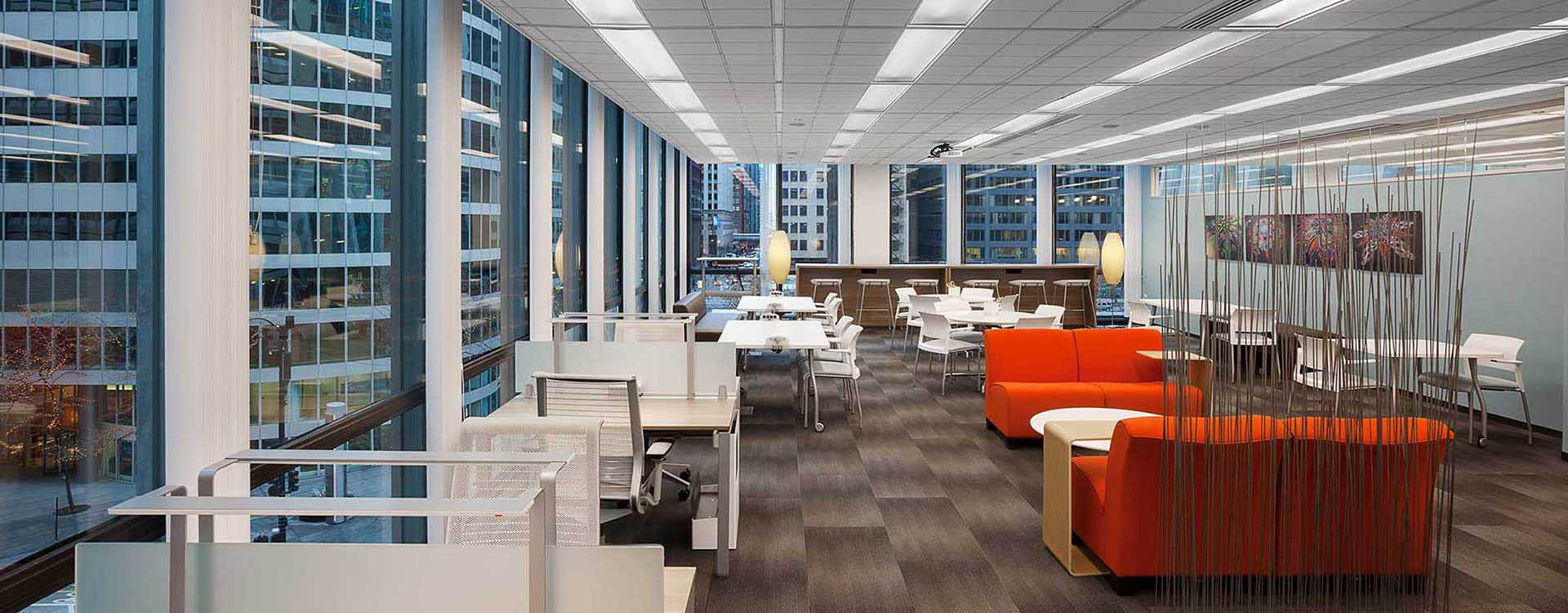 A large open office with many tables and chairs.
